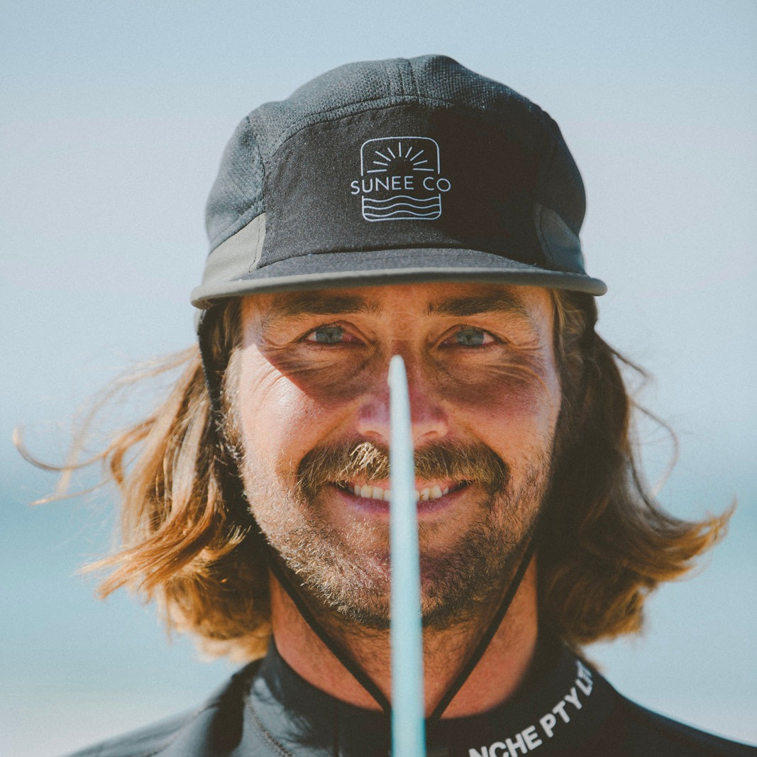 Water-resistant surf hat with adjustable chin strap with sky background